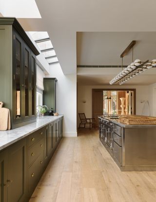 Image may contain Indoors Interior Design Floor Flooring Kitchen Chair Furniture Wood Sink and Sink Faucet