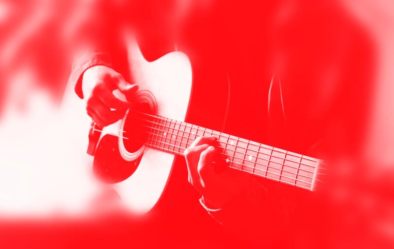 photo of someone strumming a guitar