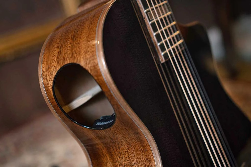 Closeup of a Cort Modern Black acoustic guitar's sideport.