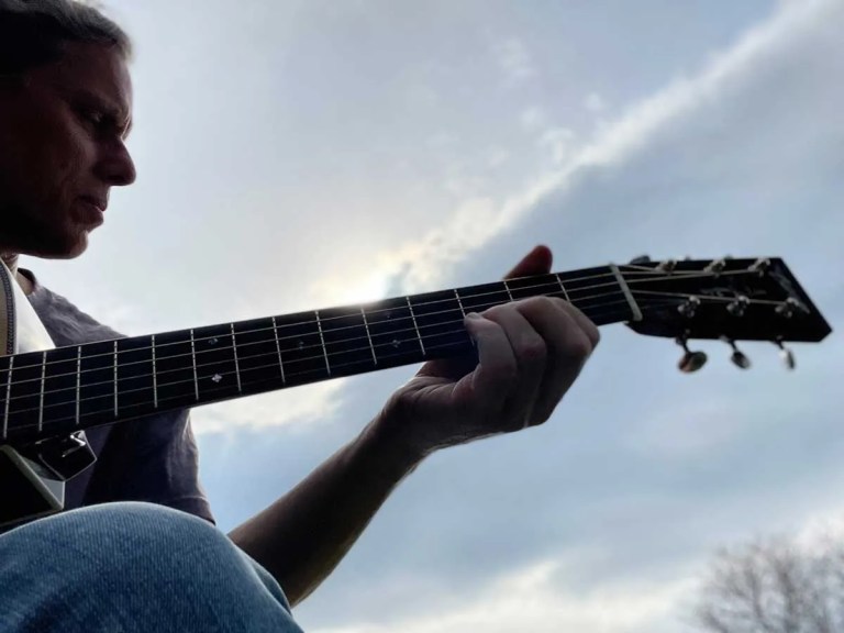 silhouette of person playing acoustic guitar against a cloudy sky background Courtesy of Jeffrey Pepper Rodgers