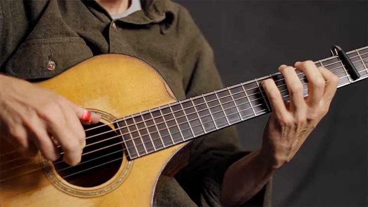Steve Baughman fingerpicking an acoustic guitar
