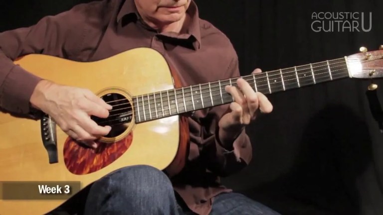close up of guitarists hand on his acoustic guitar fingerboard demonstrating this octave scale exercise
